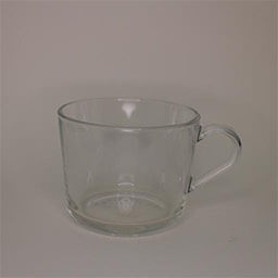 A small cylindric cup with a handle facing right 
                            A translucent cup made from glass 
                            An empty cup in studio