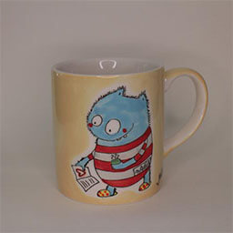 A cylindric cup with a handle facing right 
                            A yellow cup painted with a red and blue monster illustration 
                            An empty cup in studio