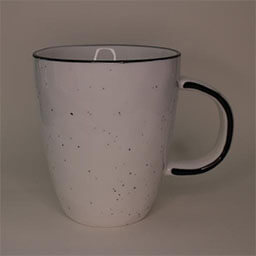 A high curved cup with a handle facing right 
                            A white cup with small black dots and a black rim 
                            An empty cup in studio