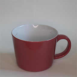 A cone shaped cup with a handle facing right 
                            A dark rose cup white on the inside 
                            An empty cup in studio