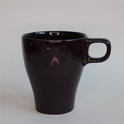 A high cone shaped cup with a handle facing right 
                            A dark brown cup 
                            An empty cup in studio
