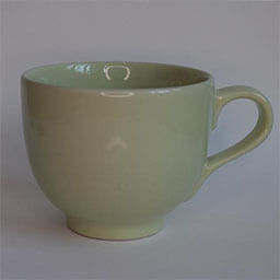 A wide rounded cup with a handle facing right 
                            A light green cup 
                            An empty cup in studio