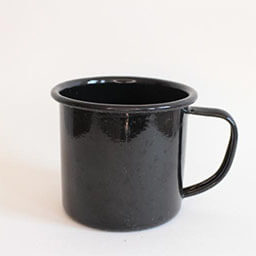 A cylindric camping cup with a handle facing right 
                            A plain black cup 
                            An empty cup in studio