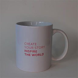 A cylindric cup with a big handle facing right 
                            A white cup printed with red text 
                            An empty cup in studio