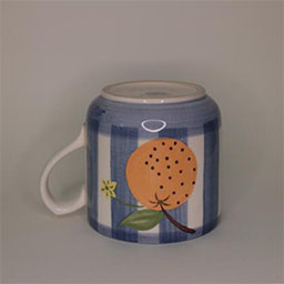 a cylindric cup turned upside down with a handle facing left a blue and white striped cup painted with an orange illustration an empty cup in studio