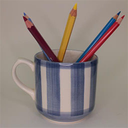a cylindric cup with a handle facing left a blue and white striped cup a cup used as a pencil holder 
                            in studio