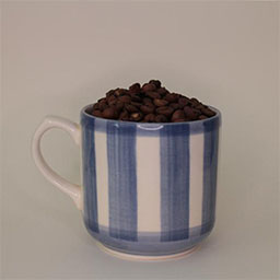 a cylindric cup with a handle facing left a blue and white striped cup 
                            a cup filled with coffee beans in studio