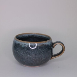 Scandinavian empty rounded dark blue stone glazed cup handle right