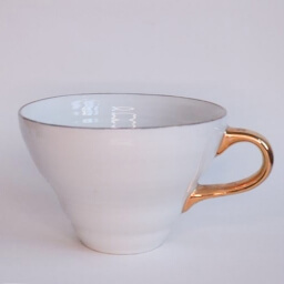 Vintage empty conic white cup golden handle right