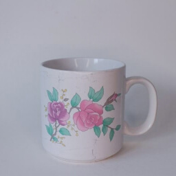 Vintage empty cylindric white rosé floral illustration cup handle right